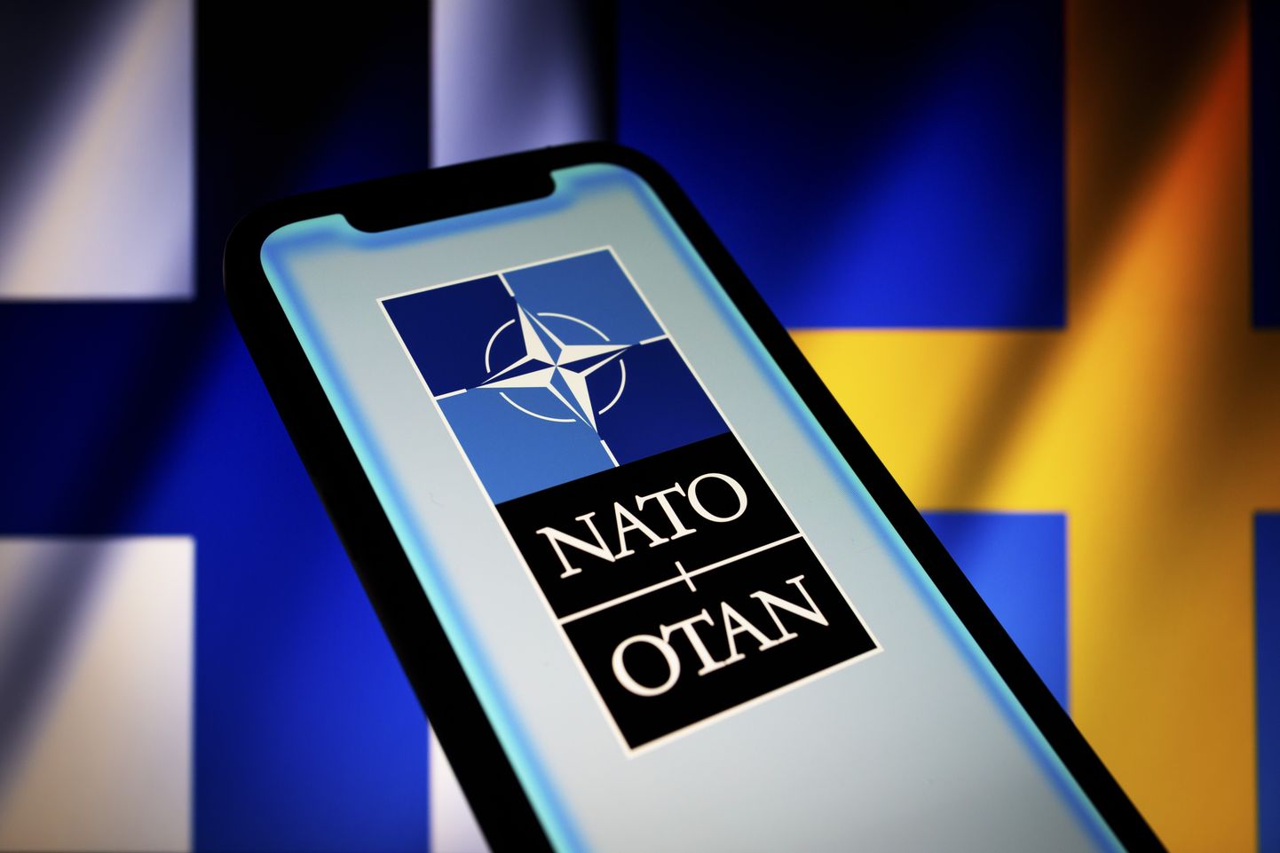 NATO logo Soome ja Rootsi lipu taustal.