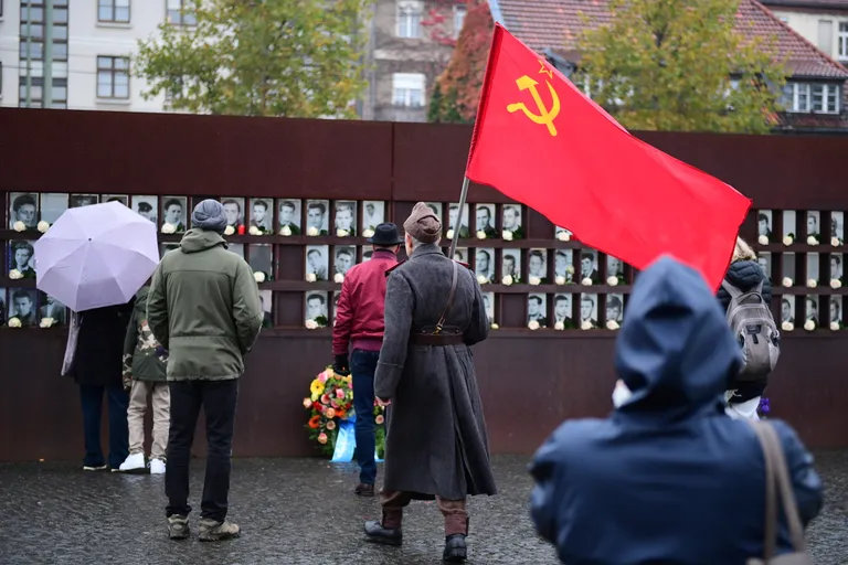 Nõukogude Liidu lipuga mees protestimas kapitalismi diktatuuri vastu Bernaueri teel Berliini müüri memoriaali juures.