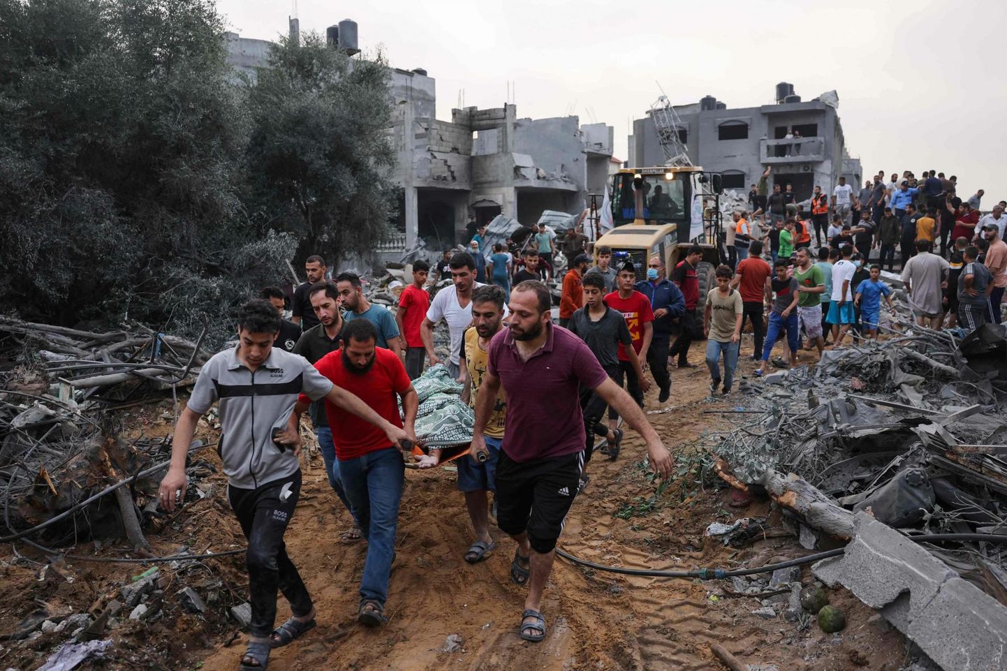 Палестинцы выносят тело жертвы из-под завалов после обстрела израильской ракетой города Рафах.