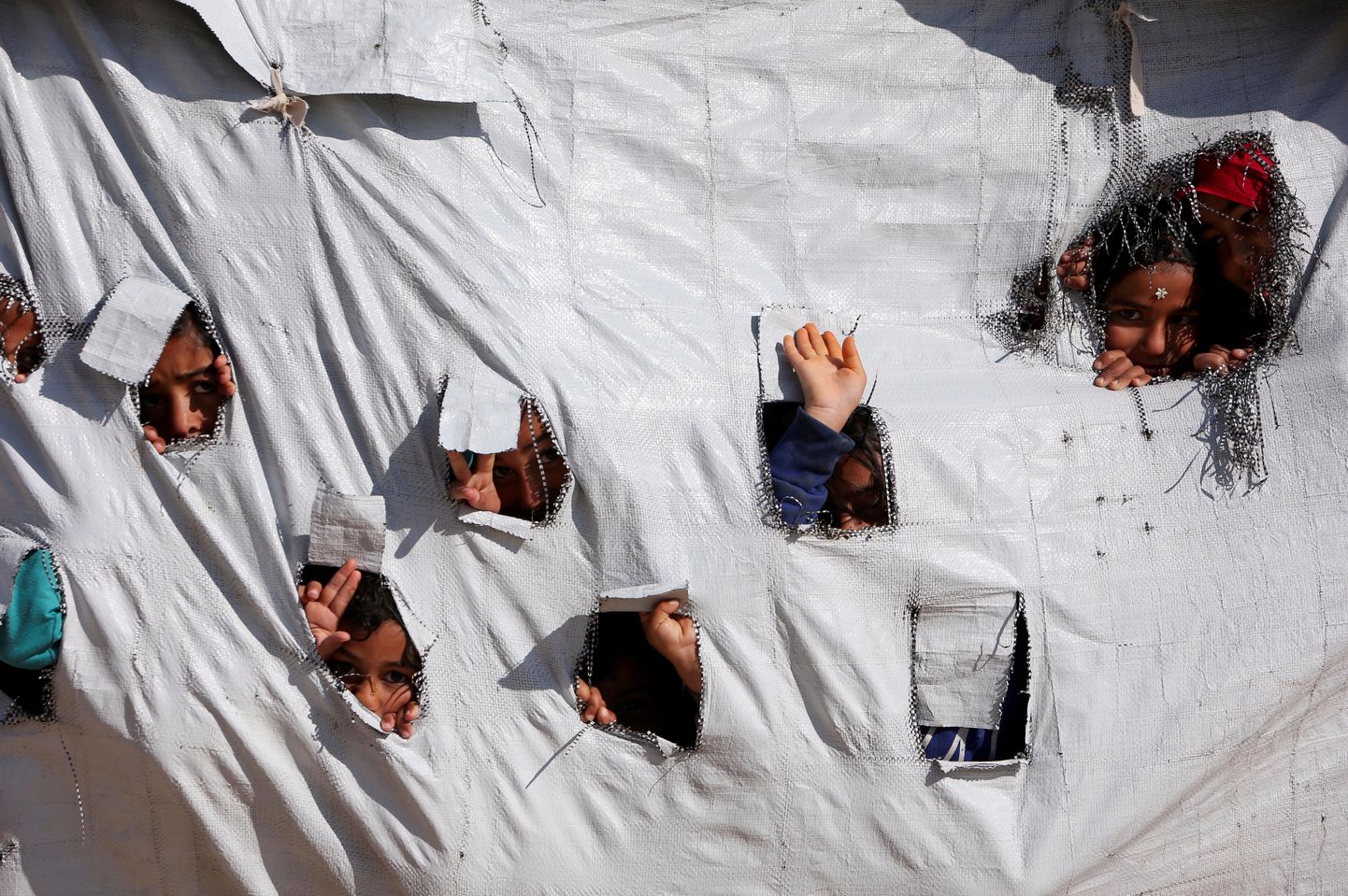 Lapsed vaatavad läbi telgi aukude al-Hol  laagris.