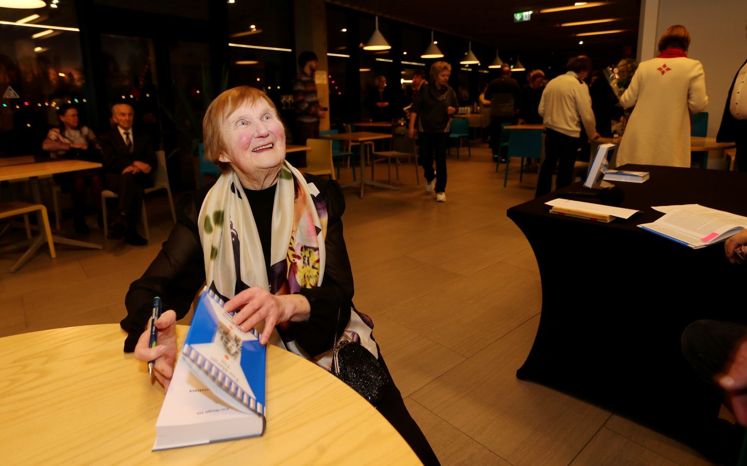 Ene-Margit Tiit annab oma raamatusse autogrammi.