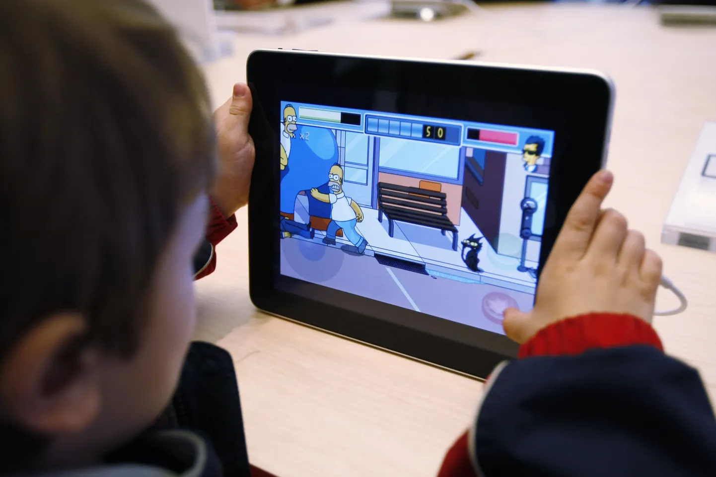5-aastane Rowan Hall San Franciscos iPadiga Simpsonite mängu mängimas.