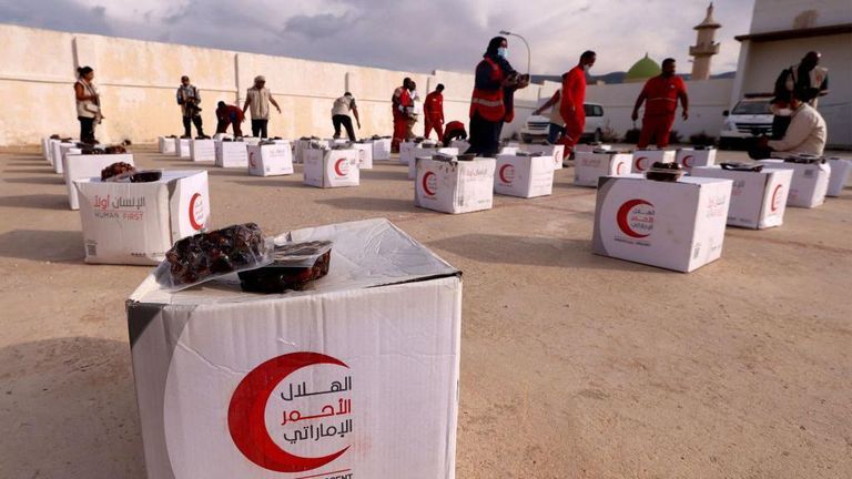Сотрудники Красного Полумесяца ОАЭ раздают продовольственную помощь пострадавшим от стихийного бедствия в Дерне