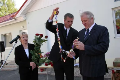 Председатель правления  Ehitaja Pinnatöötluse OÜ Аке Андрессоо (в центре) передает ключи от комнат в новом доме владельцу Южно-Эстонского центра опеки Вамбола Сипельгасу (справа). Слева завотделением попечения центра опеки Соя Сипельгас.