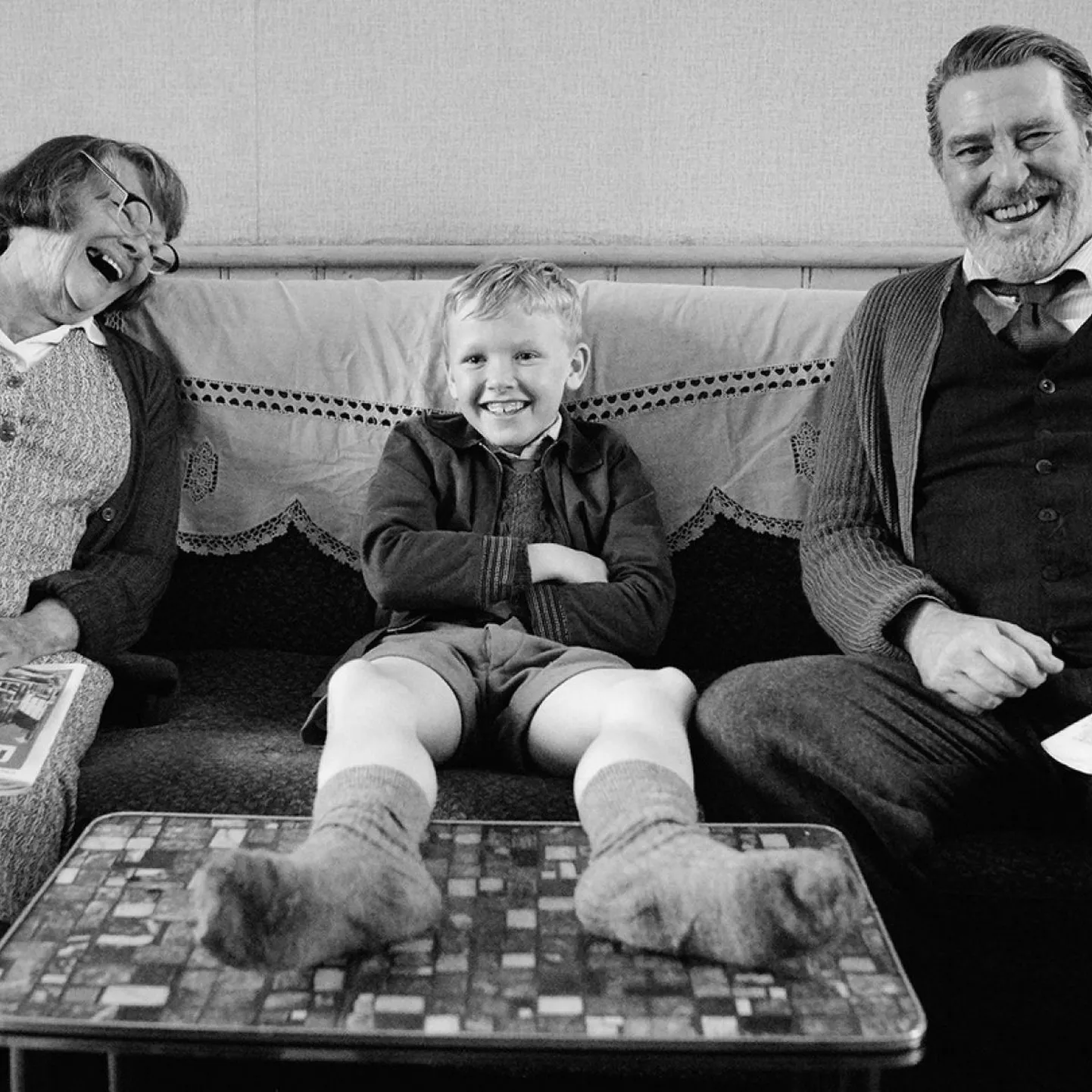 Judi Dench, Jude Hill ja Ciarán Hinds filmis «Belfast». 1960ndatel pidid seal õhtul kodu poole suundudes igal tänavanurgal tõestama, kas oled protestant või katoliiklane, kas oma või võõras.