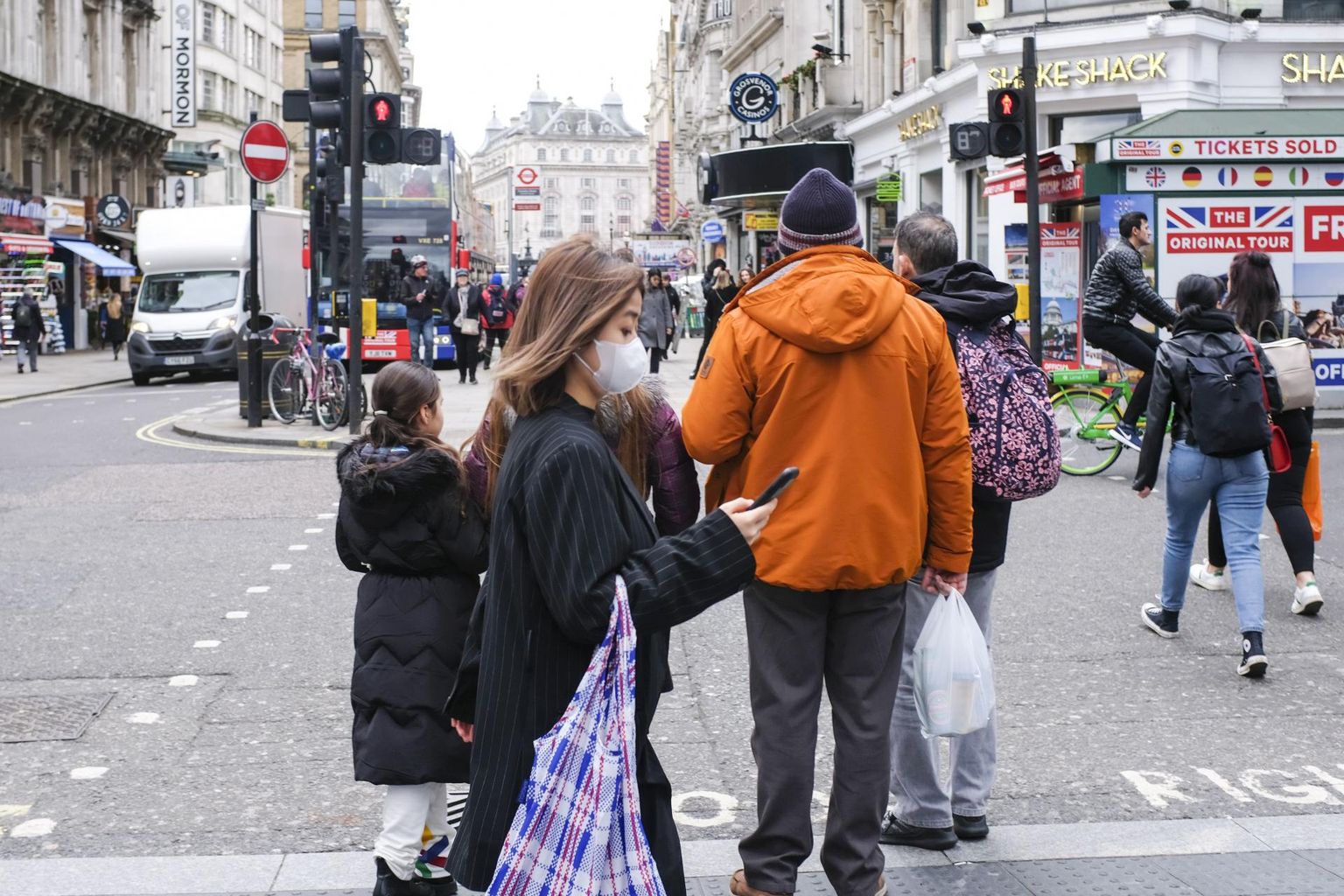 Londoni tänaval kõndiv naine püüab end koroonaviiruse eest kaitsta näomaski kandes, ent mobiiltelefonis ohustavad teda kulutulena levivad libauudised. 
