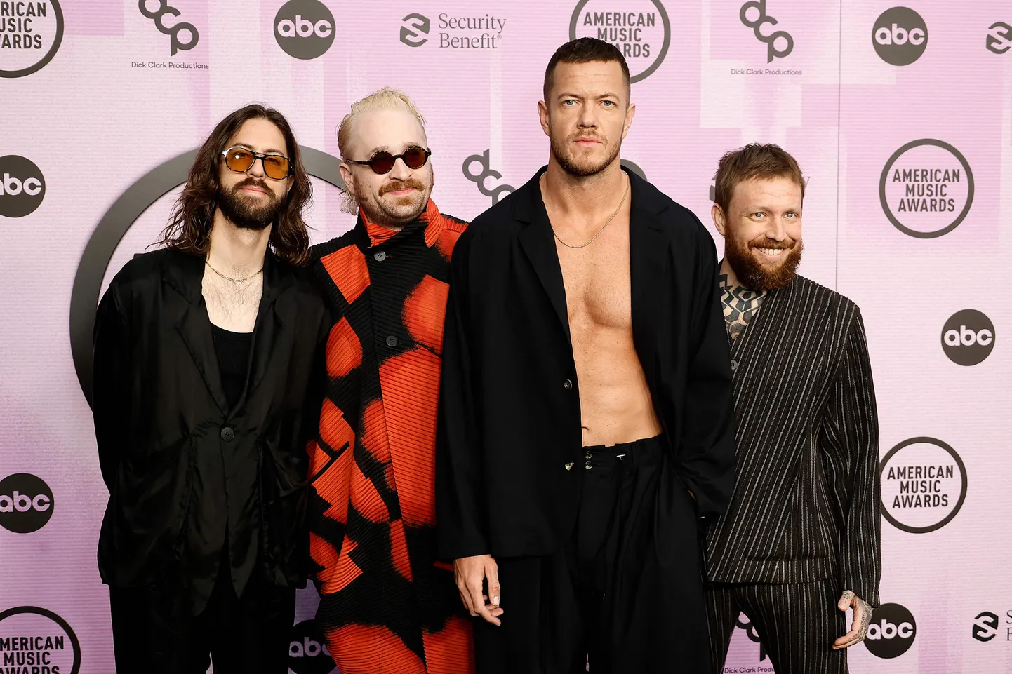 "Imagine Dragons" – (no kreisās) Daniels Veins Sermons, Daniels Placmans, Dens Reinoldss un Bens Makkī. American Music Awards balvu pasniegšanas ceremonija Microsoft teātrī Losandželosā 2022. gadā.