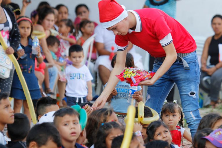 Colombia välisministeeriumi töötaja Cucutas põgenikest lastele kingitusi jagamas.