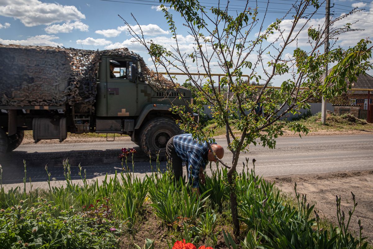 Ukraina mees korjab eile lilli Ida-Ukranas rindejoone lähedal, kui temast möödub Ukraina sõjaväemasin.