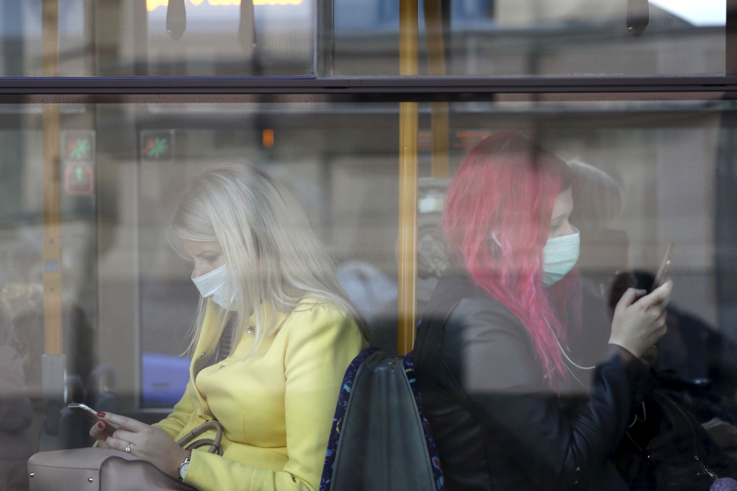 Naised maskidega Riia ühistranspordis.