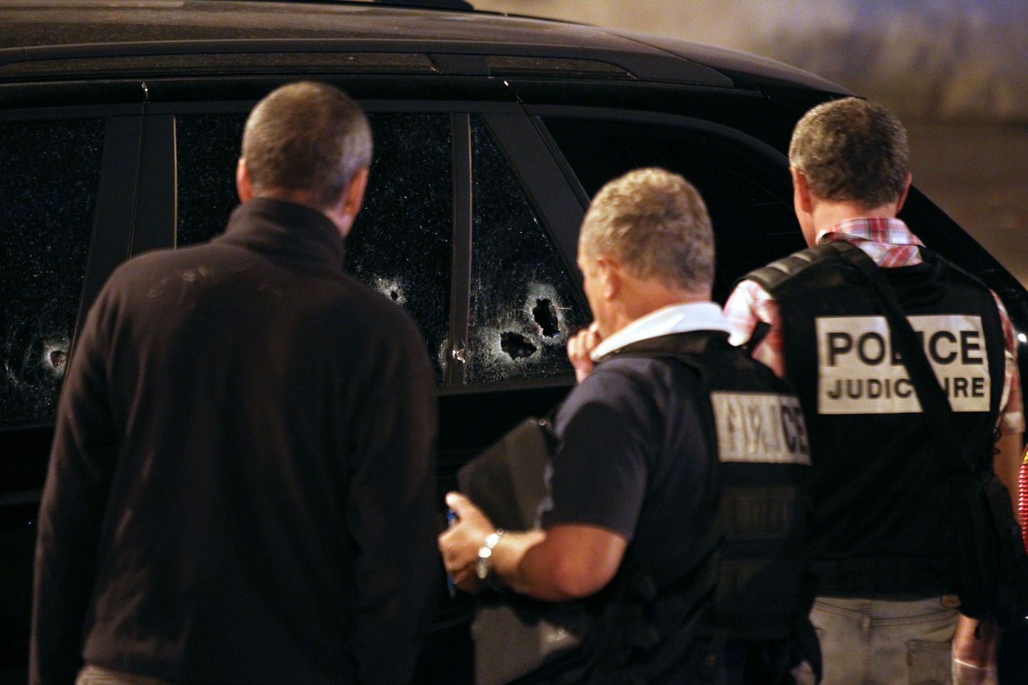 Prantsuse kohtumeditsiini- ja politseieksperdid uurivad kuulijälgedega autot.