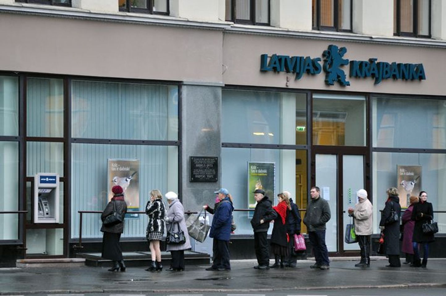 Inimesed Latvijas Krajbanka sularahaautomaadi järjekorras.