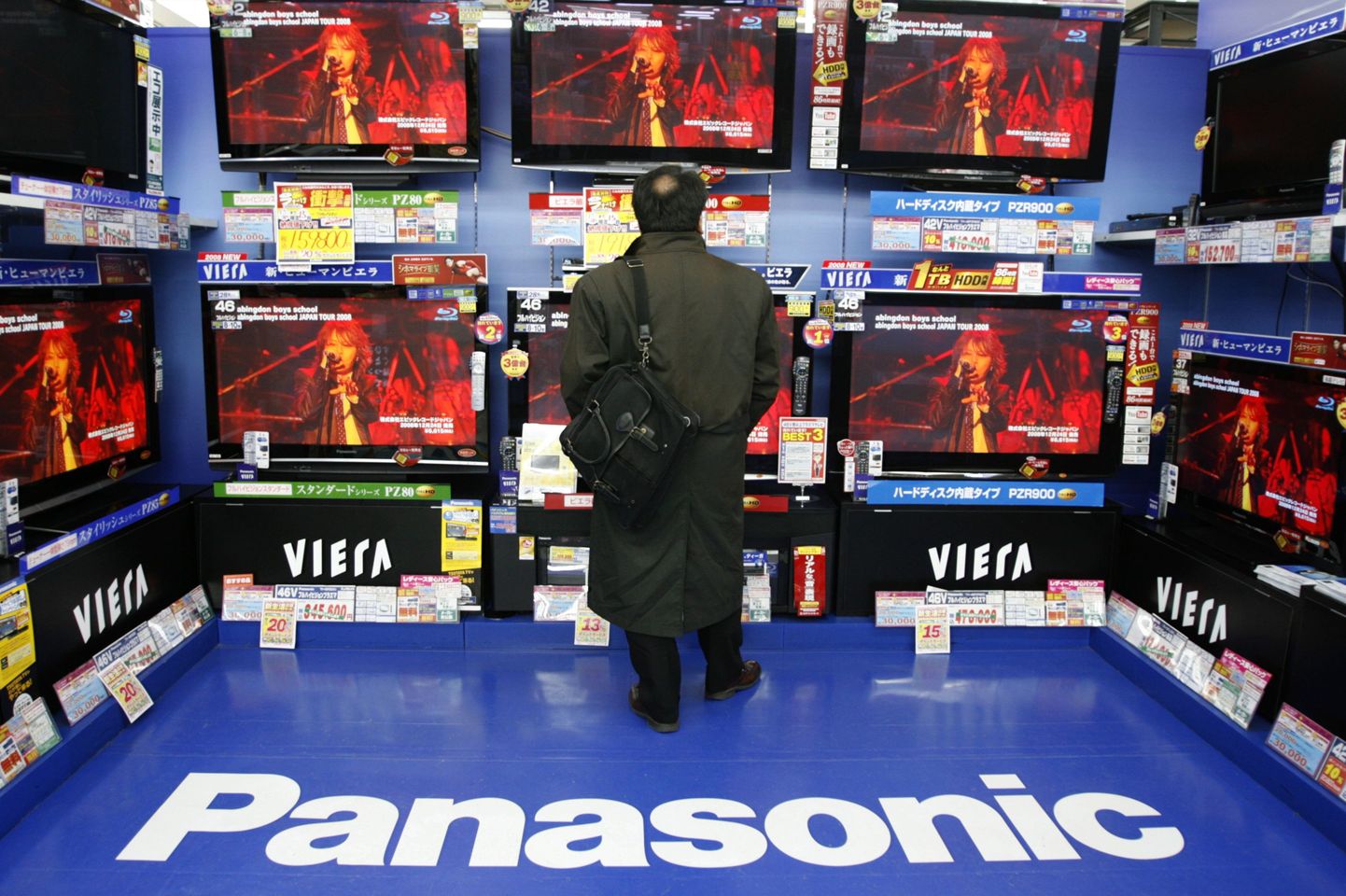 A man looks at Panasonic televisions displayed at an electronic shop in Tokyo January 28, 2009. Panasonic shares climbed 2.4 percent to 1,118 yen after the world's No.1 plasma TV maker warned it would post an annual loss of $4.2 billion and said it would cut 15,000 jobs as it grapples with a stronger yen and slowing demand.  REUTERS/Yuriko Nakao (JAPAN)