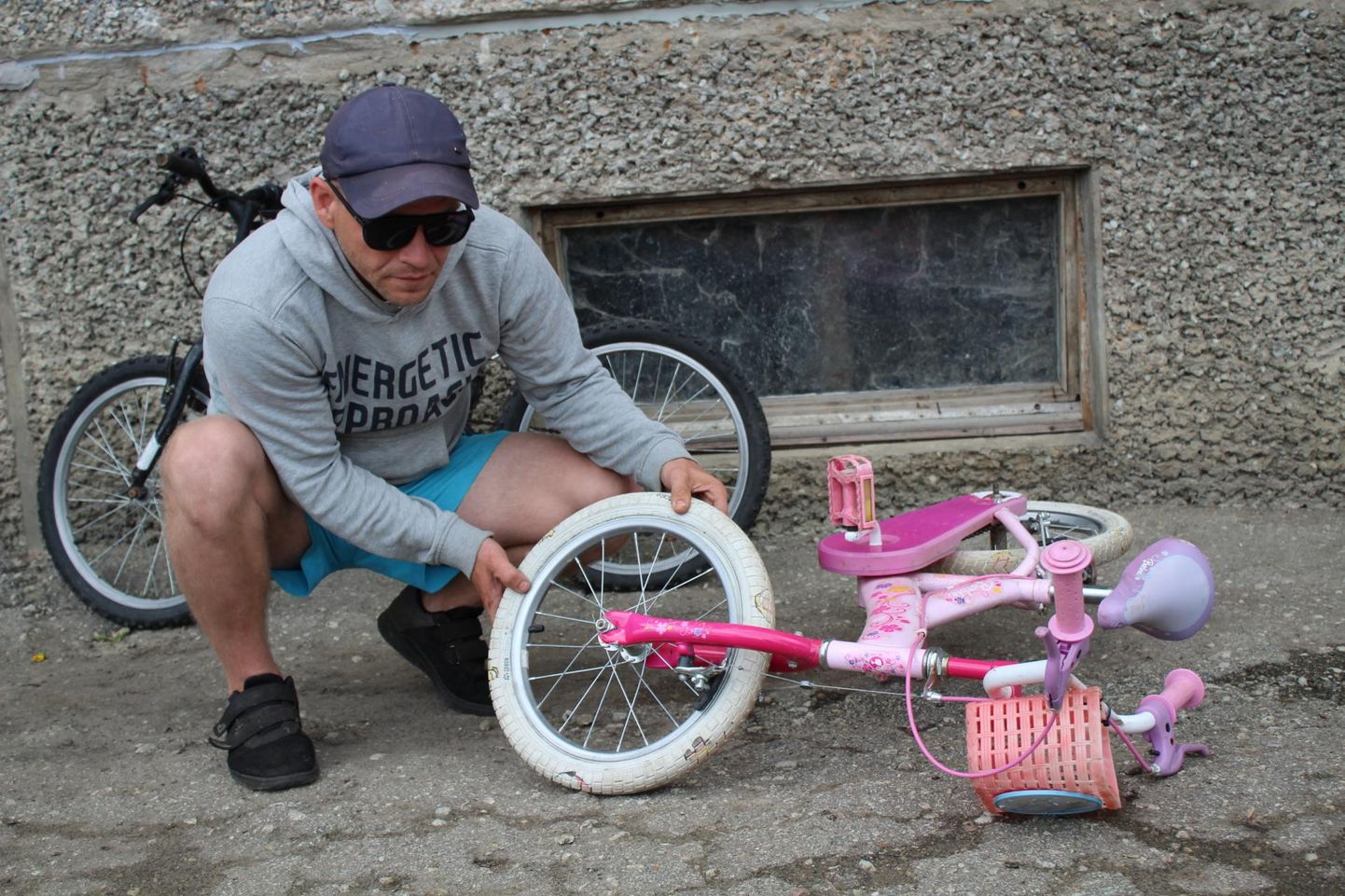 Aimar Lillepuu sündmuskohal jalgrattaga Barbie, millel on kummid läbi torgatud. Seina najal seisab ratas Donnay.