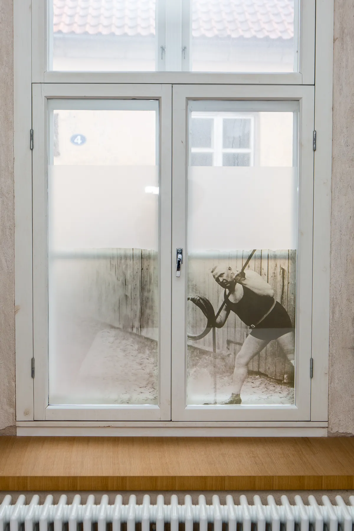 Aknale kleebitud kilefotol on Saaremaa jõumees Aleksander Sannik, kellel oli Hellega ühine esiisa viis põlve tagasi.