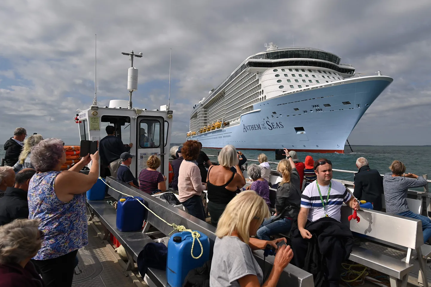 Mudeford Ferry sõidutab huvilisi vaatama Dorseti ranniku lähedal ankrus seisvaid ristluslaevu. Turistid pildistavad kruiisilaeva Anthem of the Seas.