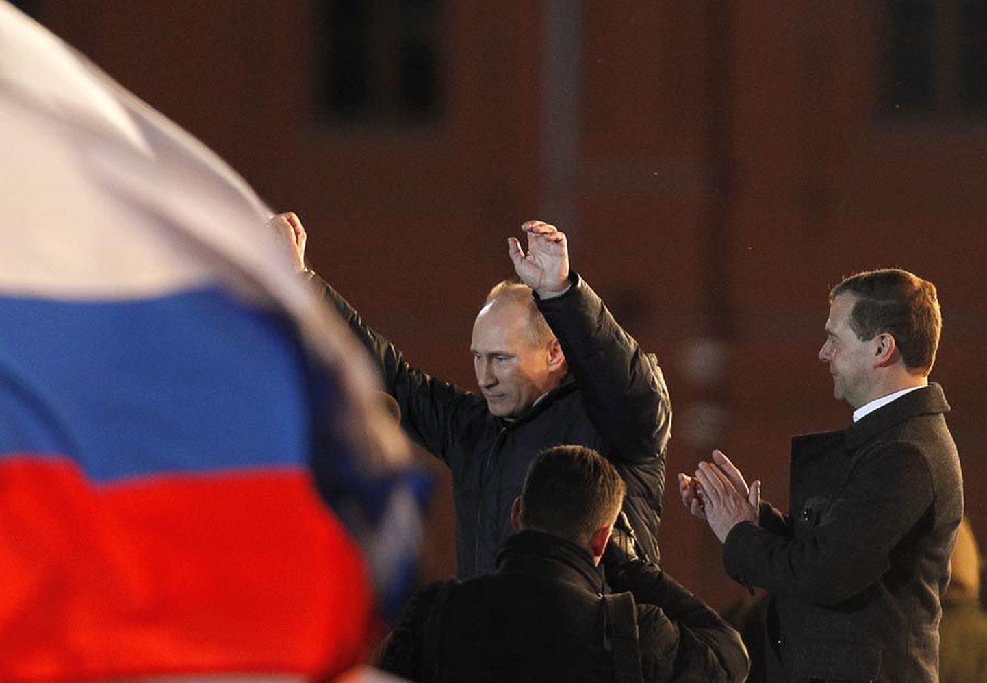 Kohavahetus: peaministrist presidendiks ja vastupidi. Vladimir Putin tõstab võidukalt käed, Dmitri Medvedjev aplodeerib.