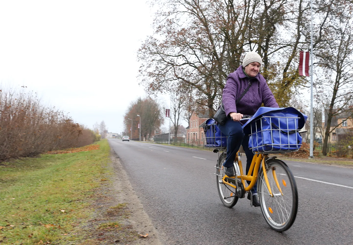 Sieviete ar velosipēdu Aucē.