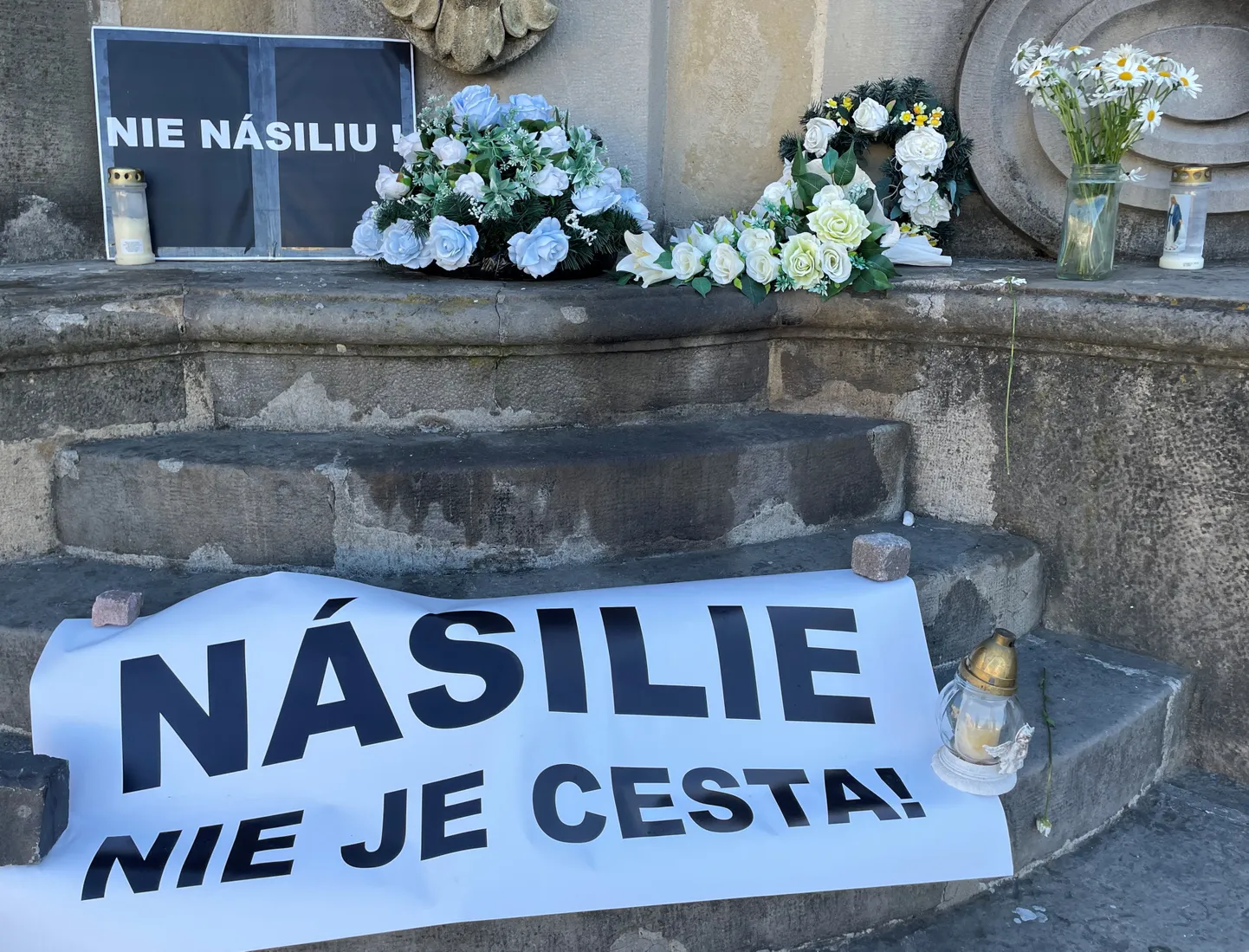 Цветы и баннер с надписью «Насилие – это не путь» после инцидента со стрельбой, в результате которого был ранен премьер-министр Словакии Роберт Фицо.