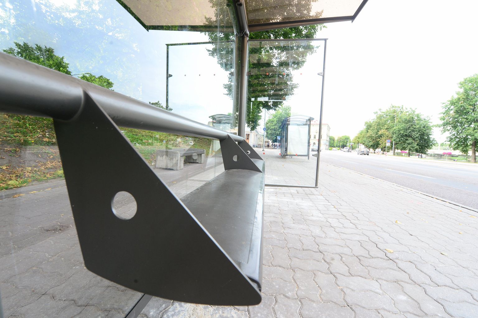Vabaduse puiesteel asuv bussipeatus koos oma torust seljatoe ja pingiga, mille istumislaual kalle.