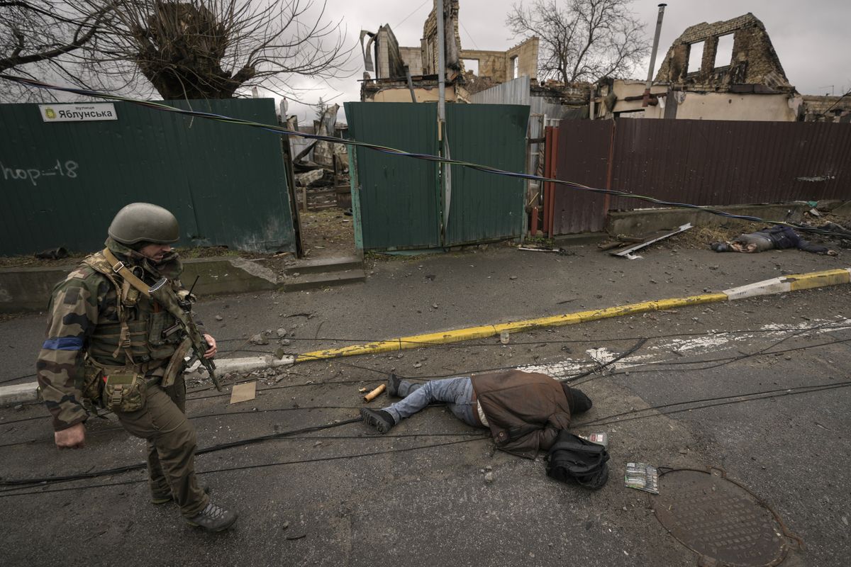 Ukraina sõdur möödub 2. aprillil Butšas tänaval lebavast surnukehast.