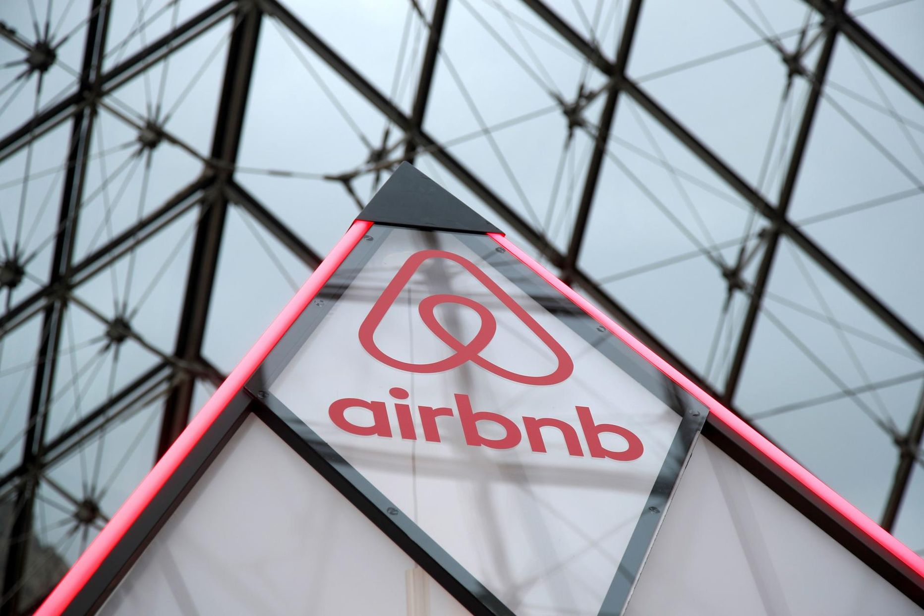 Airbnb logo väikesel püramiidil Louvre’i juures asuva klaaspüramiidi all.