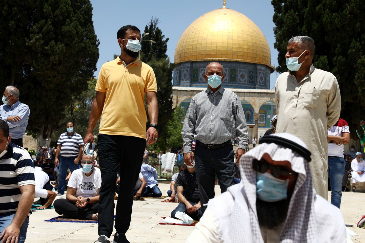 Musulmaņu vīrieši sejas maskās Izraēlā pirms lūgšanu laika
