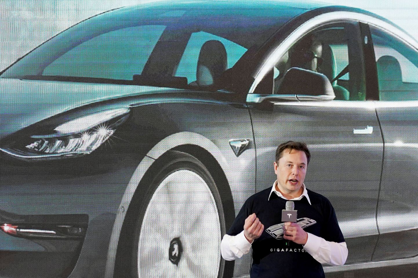 Tesla juhatuse esimees Elon Musk Hiinas toodetud Model 3-e taustal.