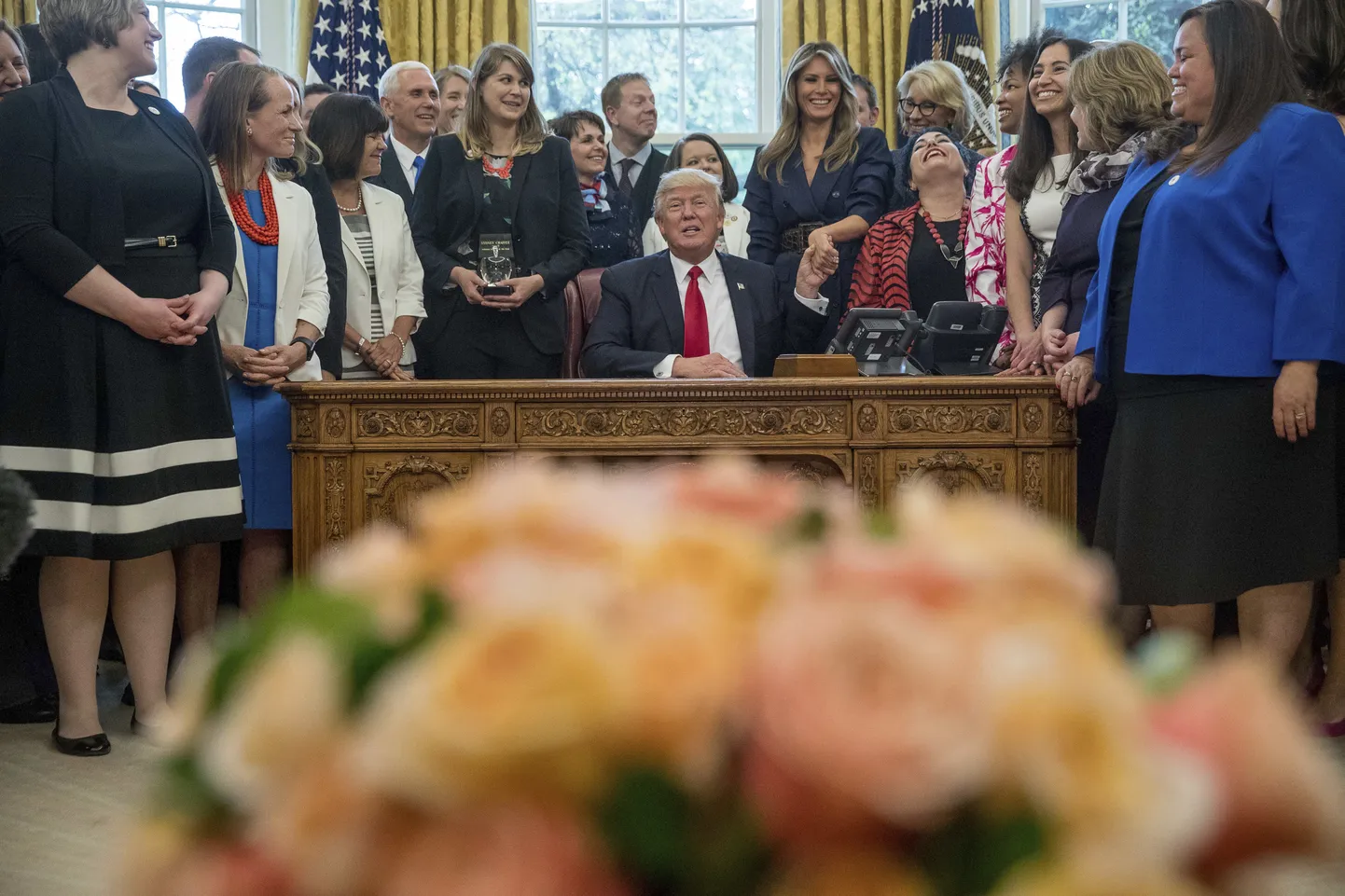 Дональд Трамп за столом с красной кнопкой.