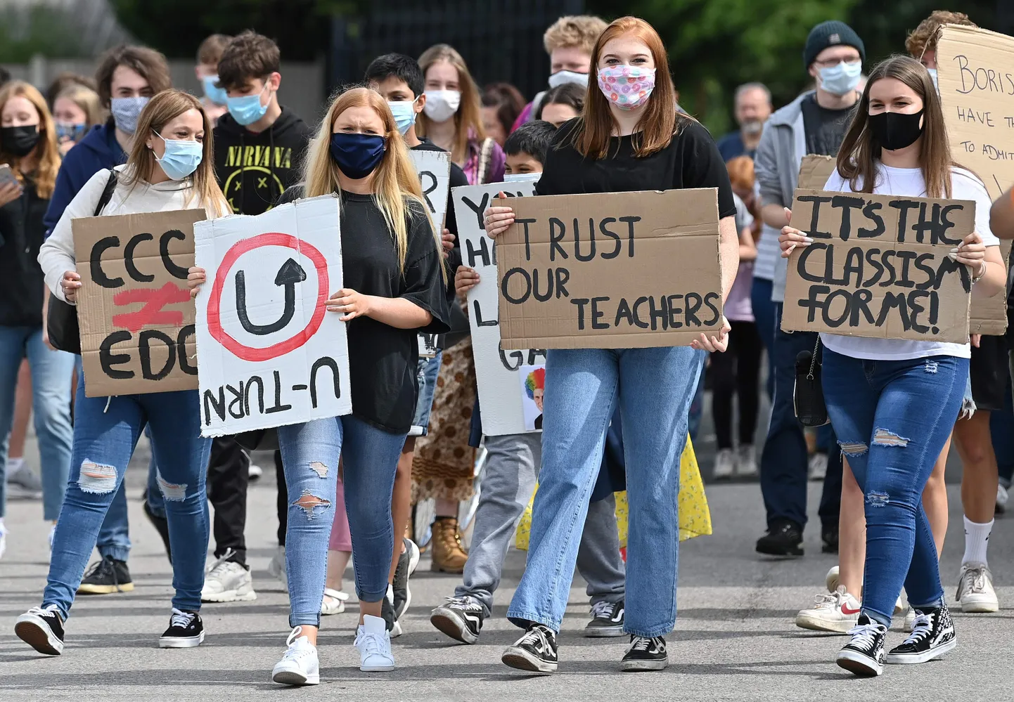 Maskides kooliõpilased protestivad haridusministeeriumi otsuse vastu alandada eksamitulemusi.