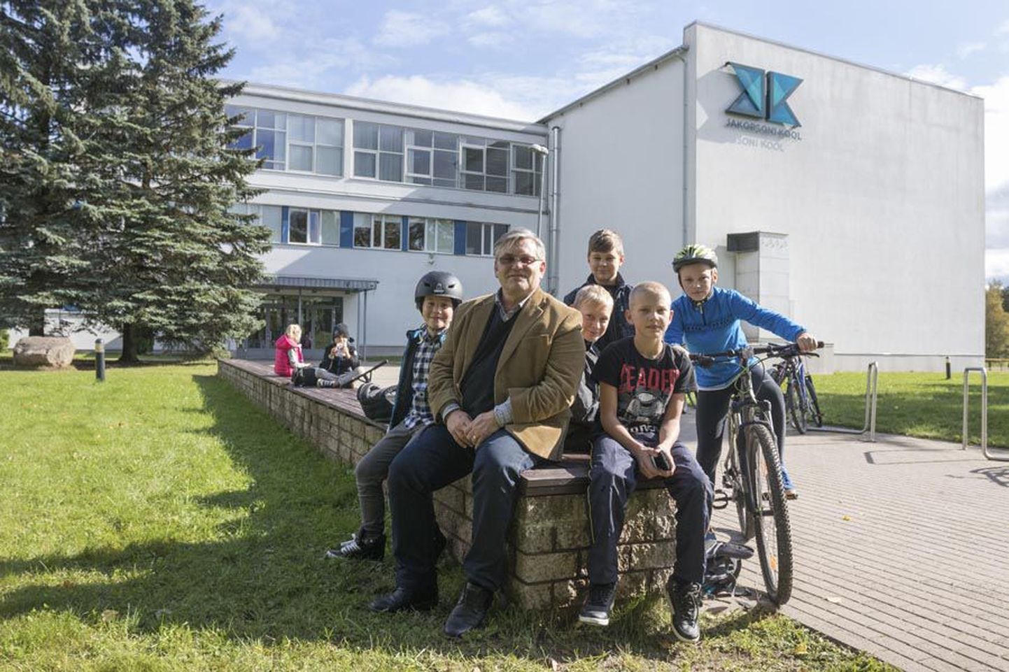 Viljandi Jakobsoni kooli direktor Tiit Kurvits koos õpilastega koolimaja ees, mis tähistab järgmisel aastal 110. aastapäeva.