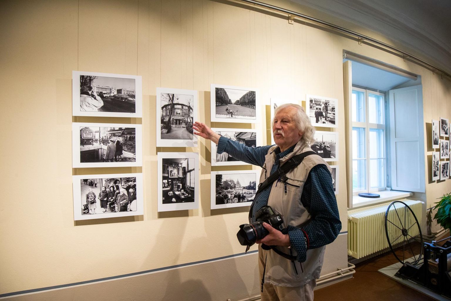 Peeter Langovits osutab fotole, millel on ümmargune hoone La Ruche ehk Mesipuu. Selles elas 20. sajandi algul mitmeid eesti kunstnikke.