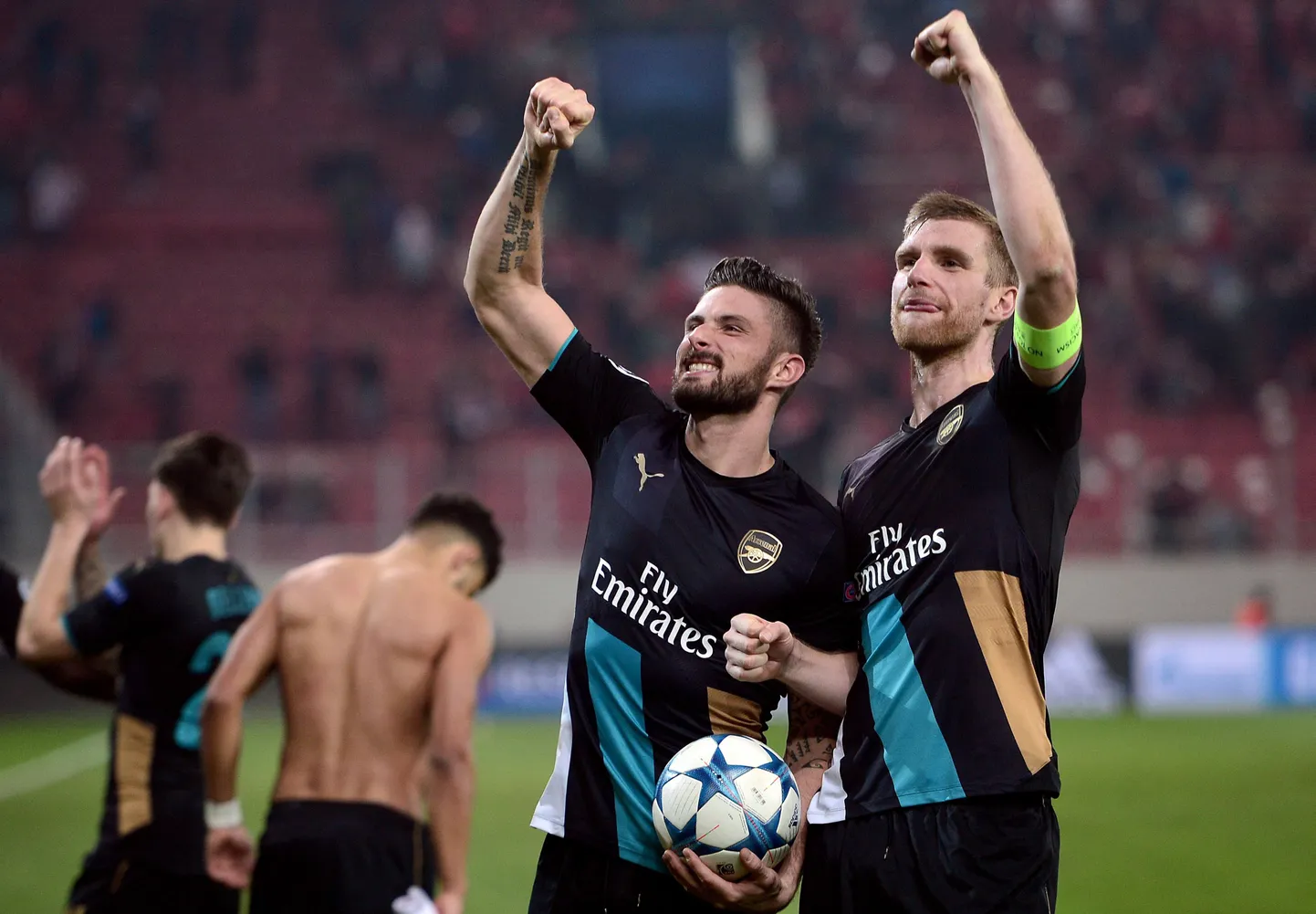 Piraeuse Olympiacose võrku kolm palli löönud Olivier Giroud (vasakul ) ja Arsenali kapten Per Mertesacker edasipääsu üle rõõmustamas.