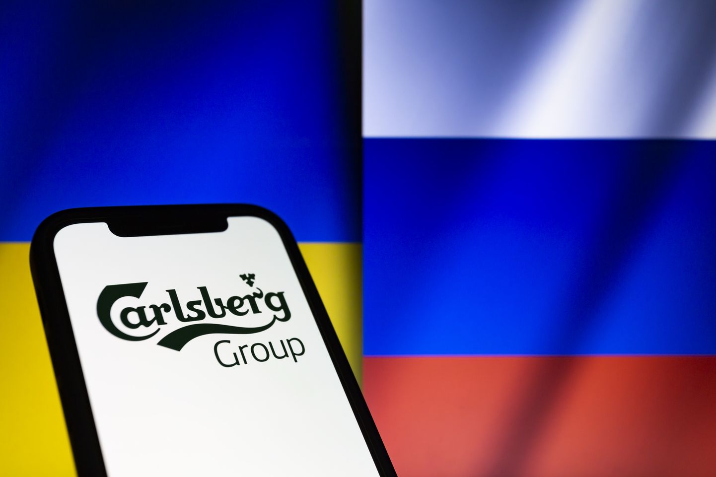 Carlsbergi grupi logo Vene ja Ukraina lipu taustal
