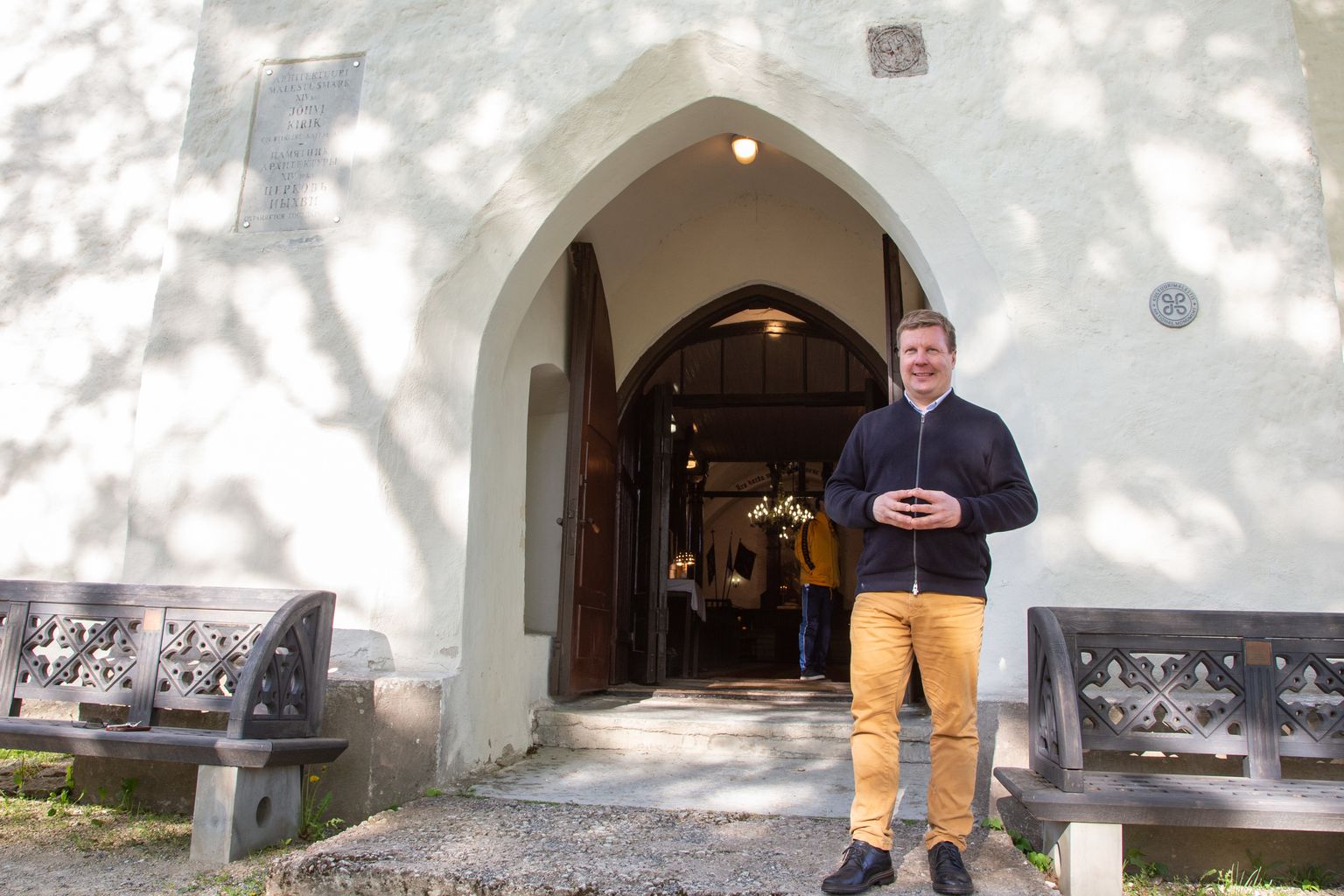 Taubede otsene järeltulija Timo Hellenberg Jõhvi Mihkli kiriku juures, sissepääsu kohal paistmas Taubede vapi kujutis.