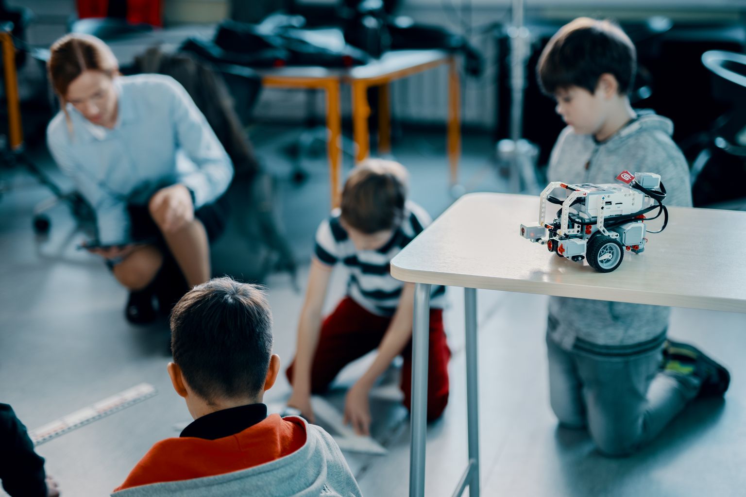 Õpilased õppimas koos väikeste robotitega.
