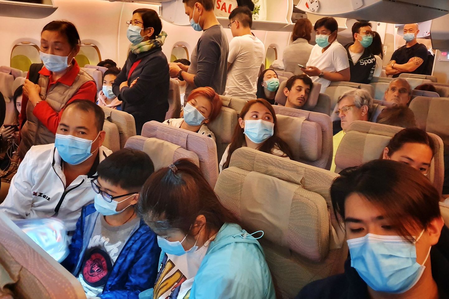 Näomaske kandvad reisjad lennukis, mis oli teel Hongkongist Bangkoki.