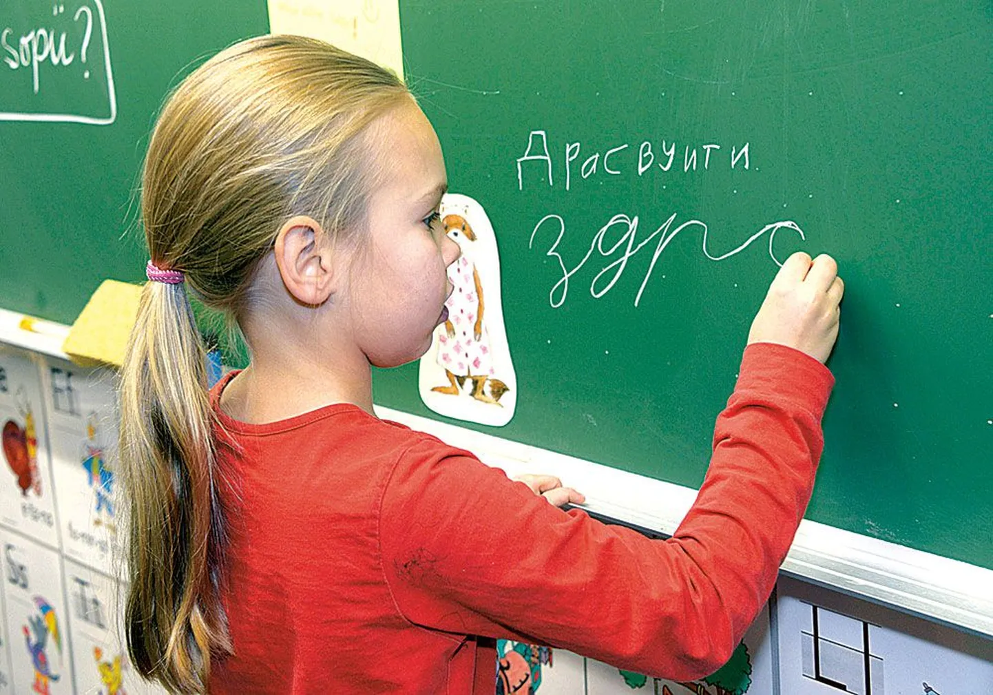 Ученица финско-русской школы в Хельсинки пишет на доске приветствие по-русски.  В Финляндии такие двуязычные школы редкость, русский язык изучают два процента учащихся. Заменить в школьной программе шведский язык русским хотели бы восемь местных самоуправлений Финляндии.