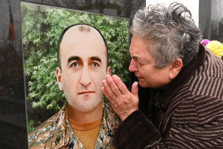 Беженка из Карабаха у могилы сына погибшего в последней войне.