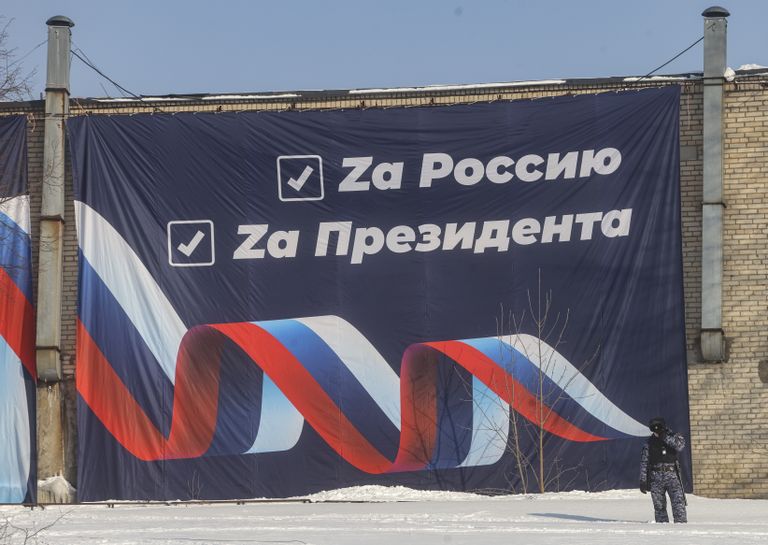 Plakāts slēpošanas trases malā, kas vēsta: "Par Krieviju, par prezidentu".