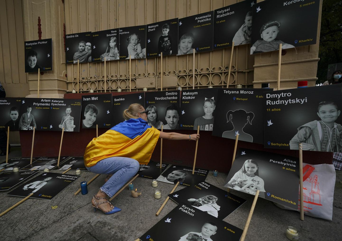 Ukraina kodanik asetab Mehhiko Vene saatkonna ette plakateid sõjas tapetud laste fotodega.