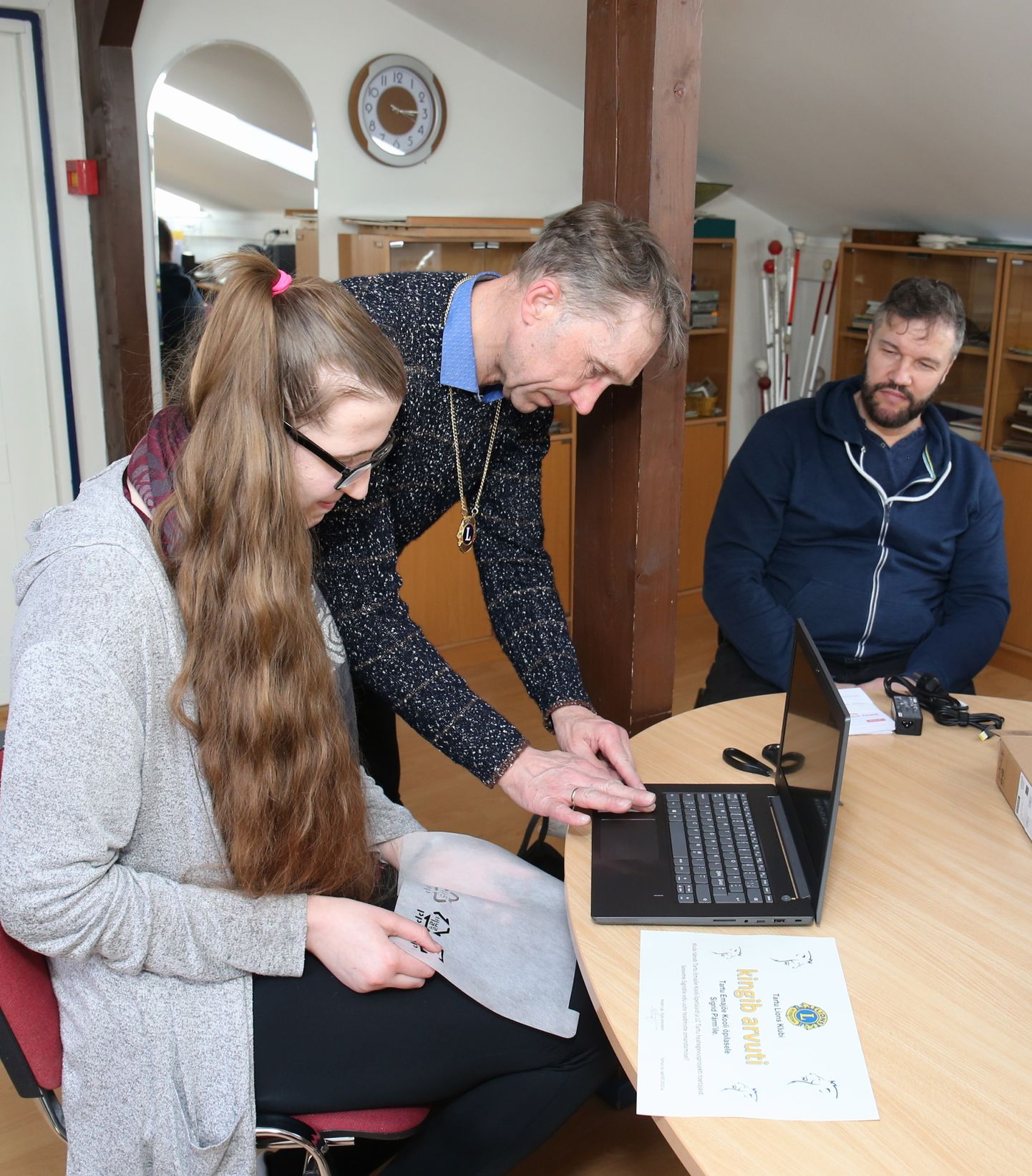 Emajõe kooli õpilane Sigrid Pärm on avanud sülearvuti kaane ning Tartu Lionsi klubi president Madis Ligi kontrollib, kas klahvid ka töötavad.