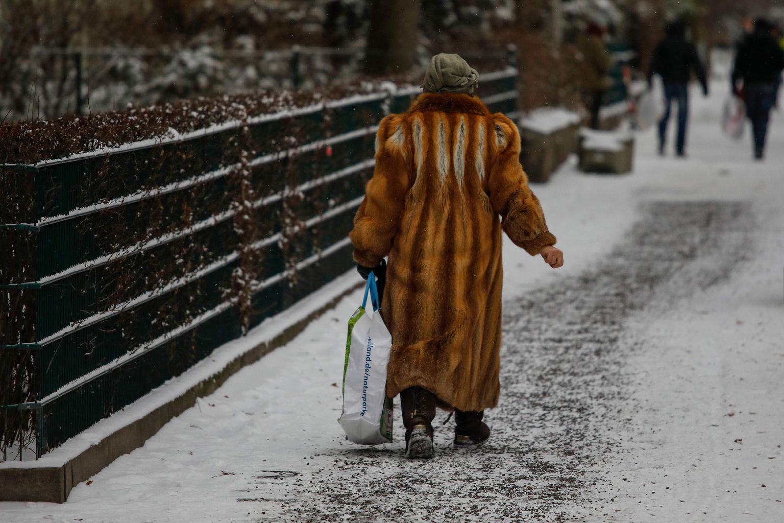«Ostmisest hoidumise» keskkondades vahetab omanikku üha rohkem riideesemeid. Pildil karusnahast kasukaga vanadaam kerges lumesajus Berliini Kreuzbergi linnajaos 2021. aasta 7. veebruaril.