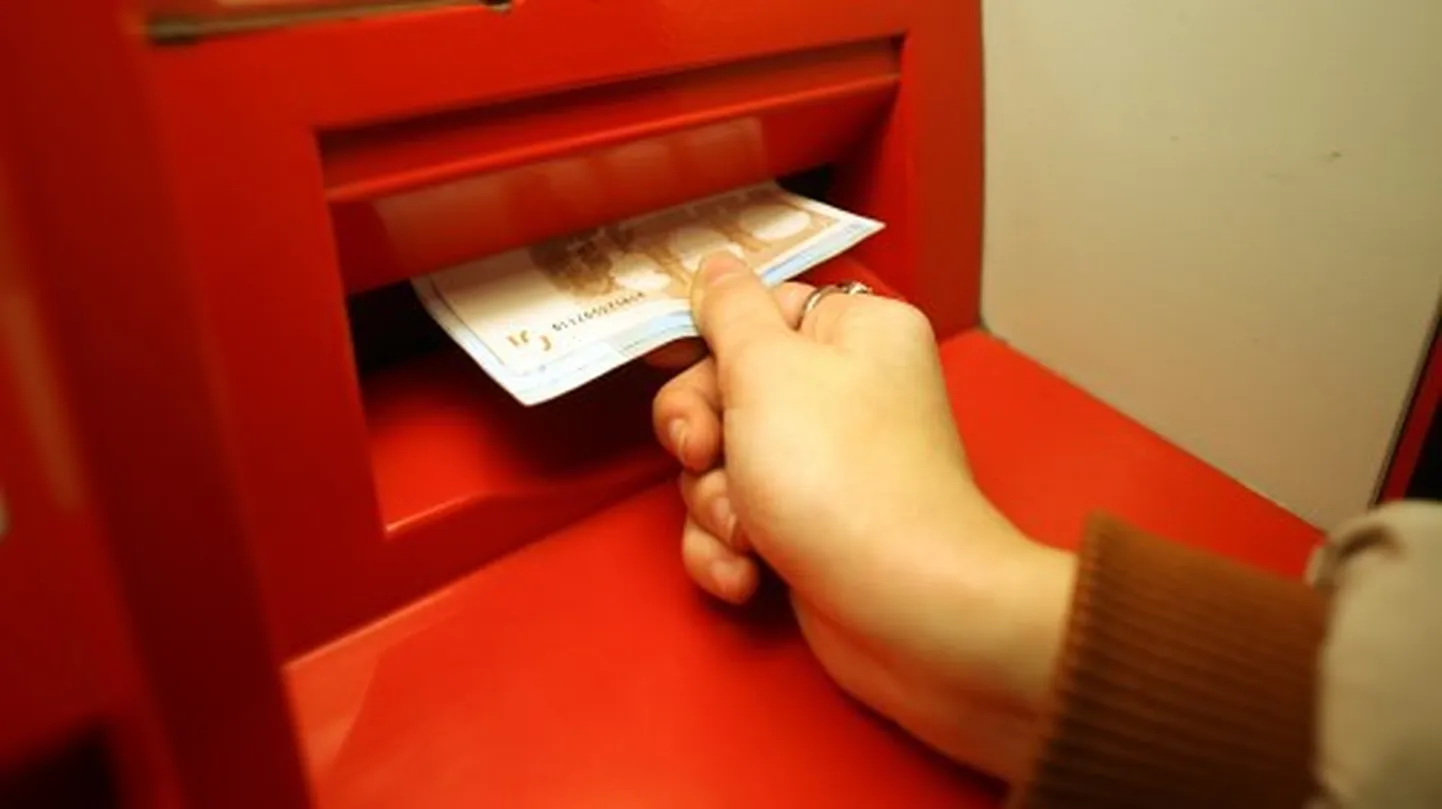 Cilvēks izņem eiro banknotes no bankas "Citadele" bankomāta.