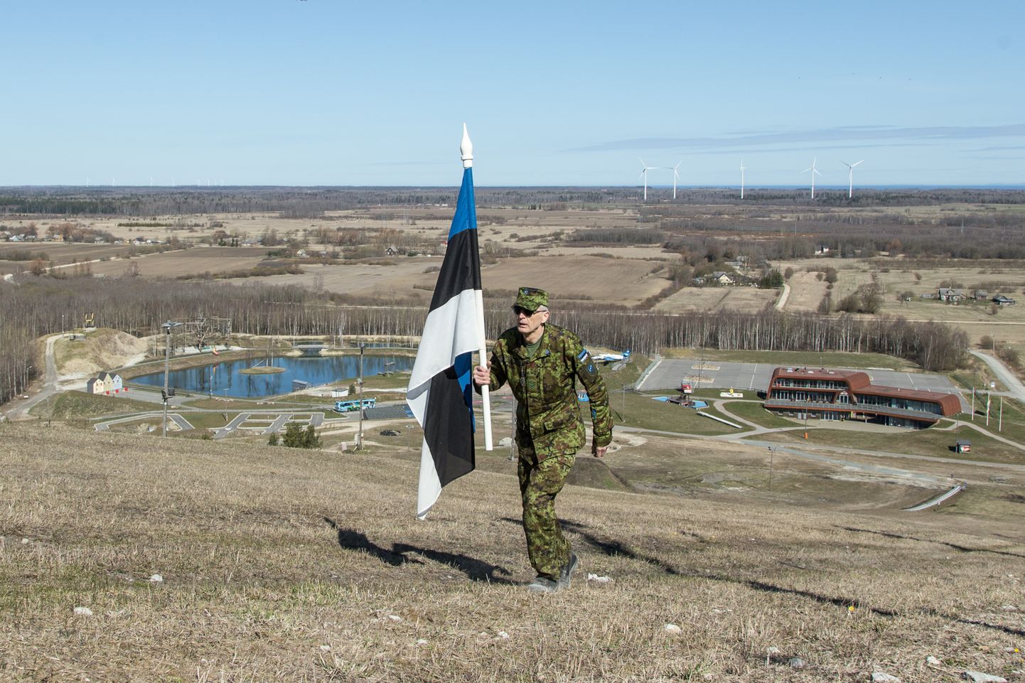 Aivar Raudsepp rühkimas veteranipäeval Eesti lipuga Kiviõli mäe tippu, mille kõrgus jalamist on 90 meetrit.