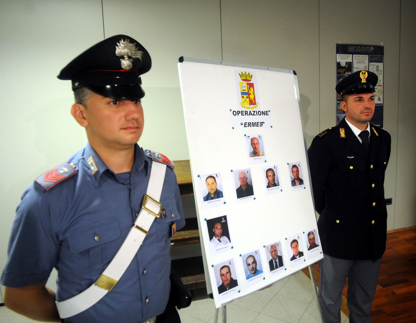 Itaalia karabinjeerid hoidmas 2015. aastal plakatit 11 isiku fotodega, kes abistasid väidetavalt maffiasündikaat Cosa Nostra tagaotsitavat liidrit Matteo Messina Denarot.