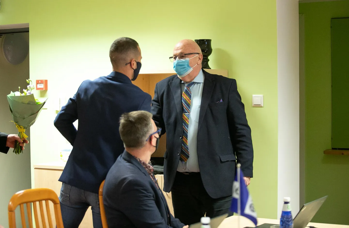 Pärast valimisi 2021. aasta novembris: Einar Vallbaumist sai taas Viru-Nigula vallavanem, teda õnnitleb praegune umbusaldaja Ainar Sepnik (seljaga). Fotole on jäänud ka volikogu aseesimees Allar Aron.