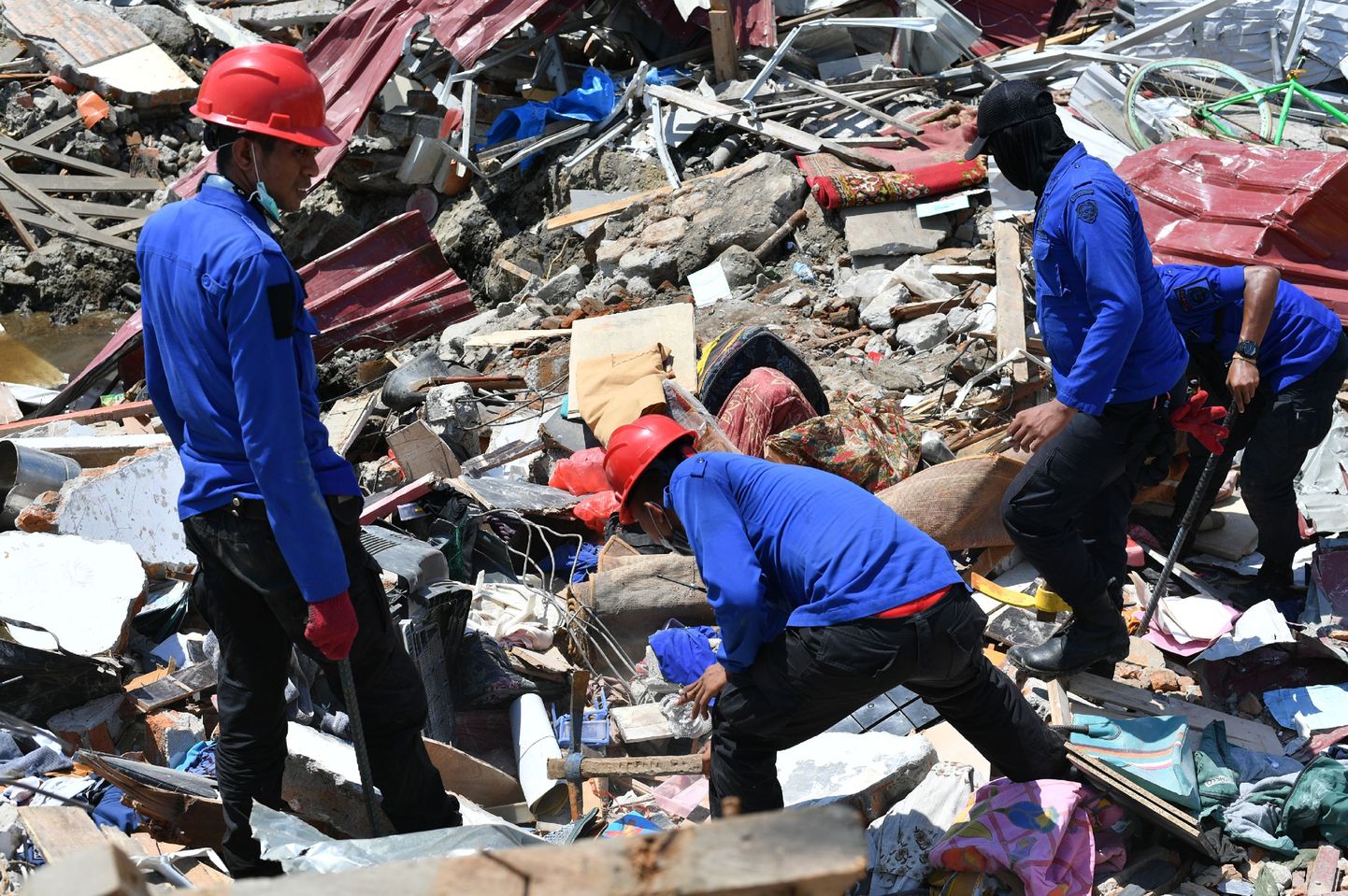 Indonesian search and rescue members look for survivors in Palu, Indonesia's Central Sulawesi on October 2, 2018, after an earthquake and tsunami hit the area on September 28. - The bodies of dozens of students have been pulled from their landslide-swamped church in Sulawesi, officials said on October 2, as an international effort to help nearly 200,000 Indonesia quake-tsunami victims ground into gear. (Photo by Adek BERRY / AFP)