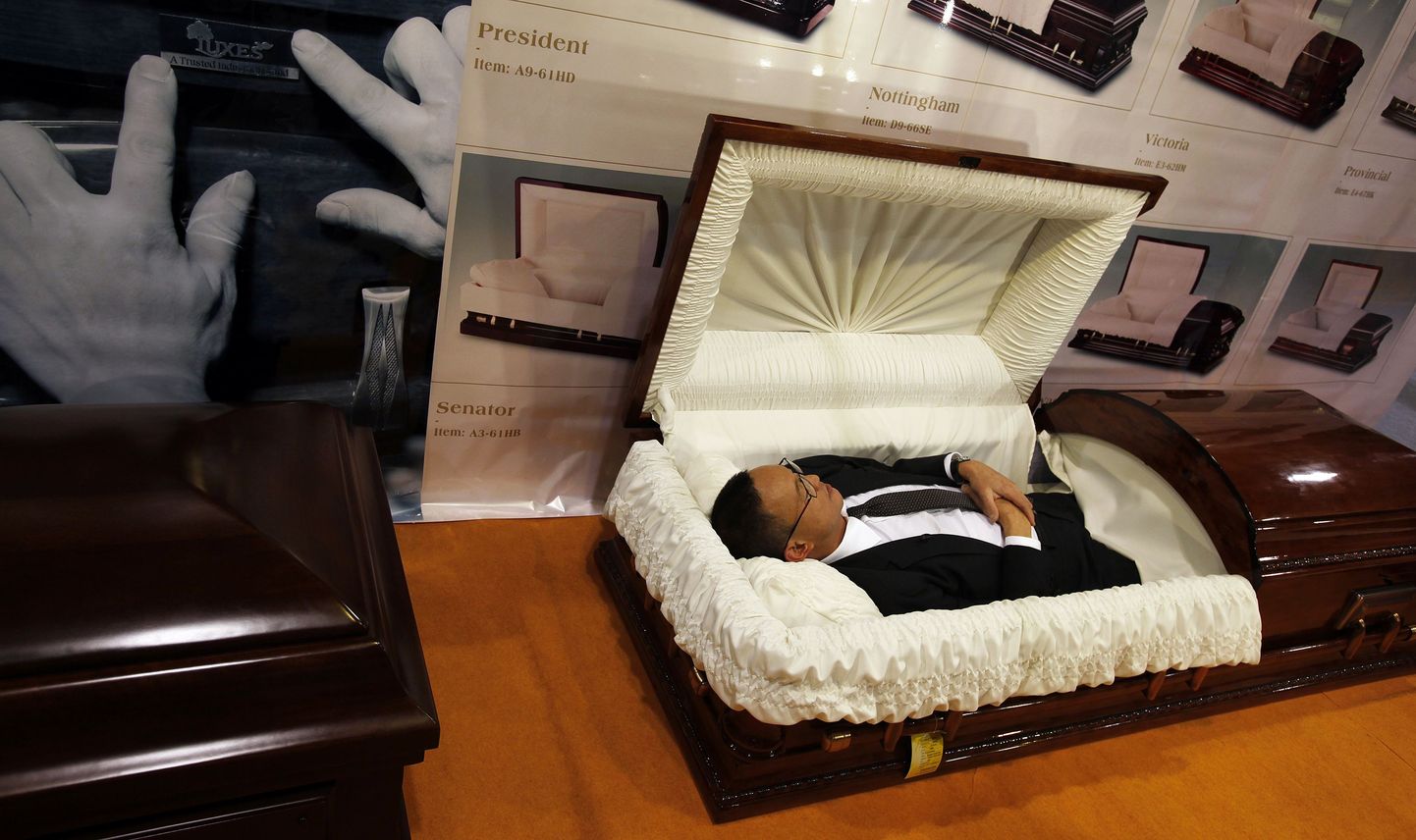 Hongkongi teleajakirjanik matusemessil kirstu katsetamas