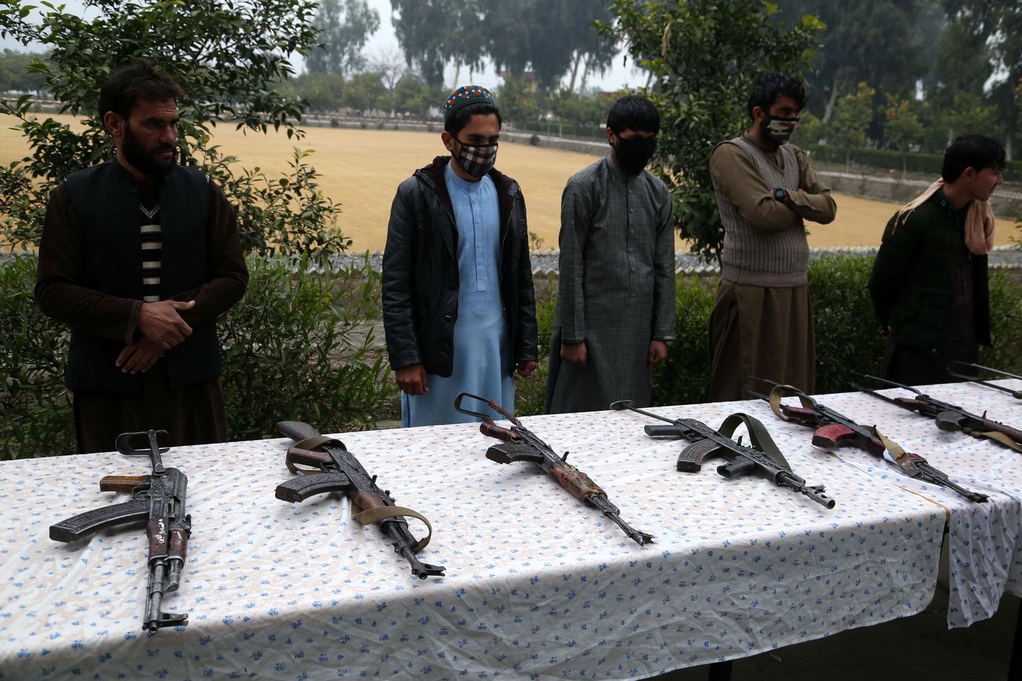 Bijušie "Taliban" kaujinieki noliek ieročus.